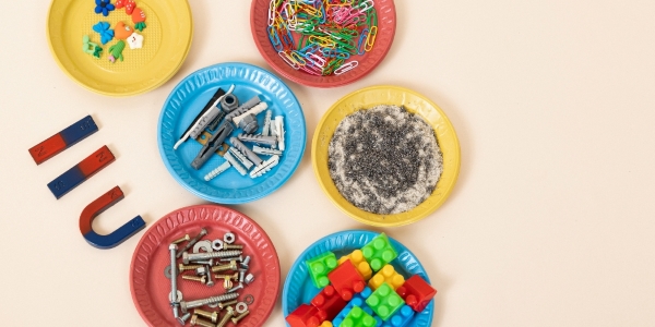 six colourful paper plates holding various loose items like paper clips, nuts and bolts, metal screws, and LEGO piecesand