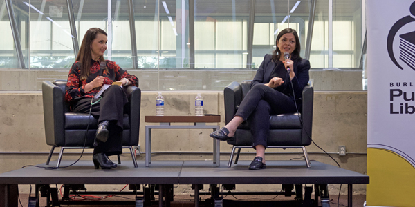 two authors in conversation seated in chairs on a stage
