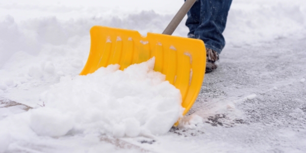 shovelling snow with a yellow shovel