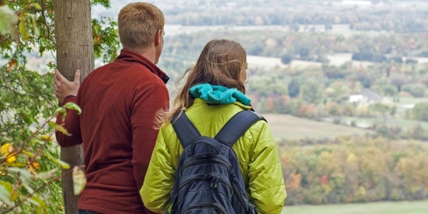 two adult hikers looking at view from an elevation