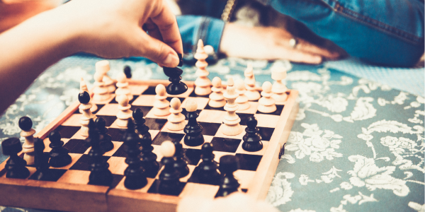 A closeup photograph of two people playing chess.