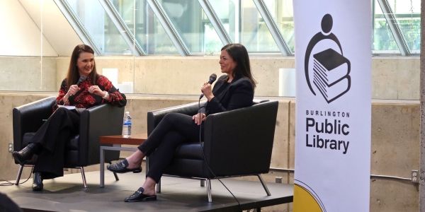 two authors in conversation seated in chairs on a stage