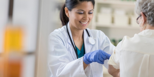 adult giving flu shot to an older person