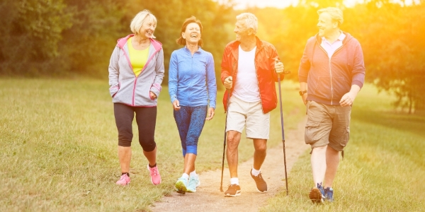 four adults walking along a path in a field