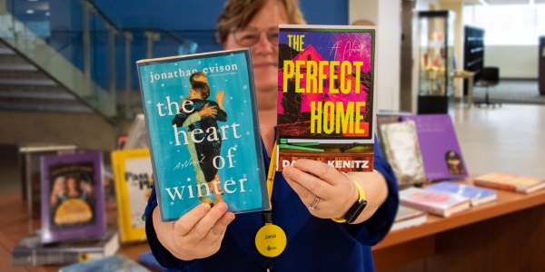 library staff holding up two books