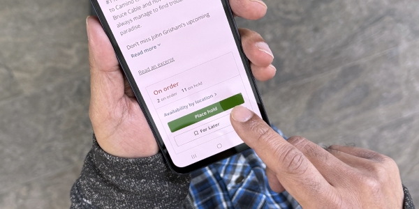 hand holding a mobile phone displaying the library catalogue