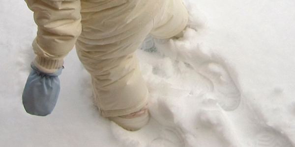 child in snowsuit walking in snow