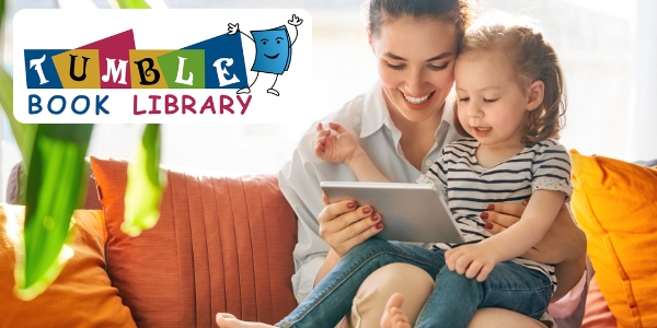 adult and young child looking at a tablet together while sitting on a couch.