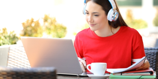 adult wearing headphones looking at a laptop