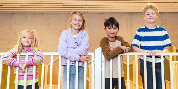 four youth standing against a railing