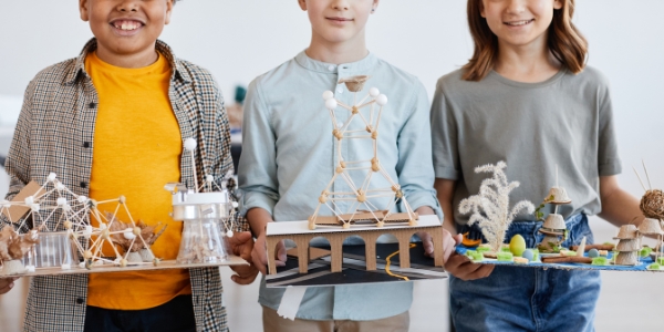 three children holding science projects