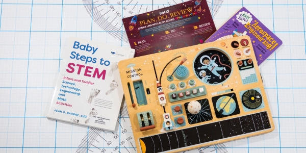 space station kits with two books, a wooden activity board, and a laminated information sheet.