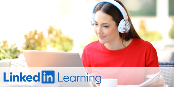 young woman wearing headphones using a laptop beside LinkedIn Learning logo