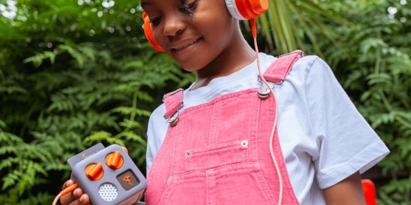 child wearing headphones holding a yoto mini player