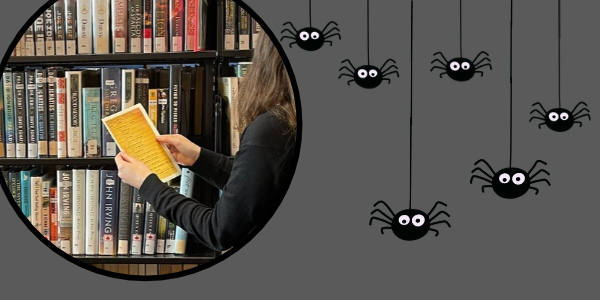 a person standing at a book shelf holding a piece of paper with writing on it