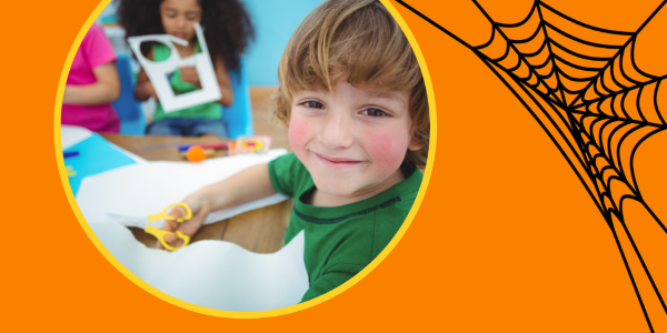 smiling child holding scissors and looking at the camera