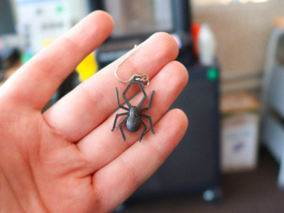 hand holding a 3D printed spider earring