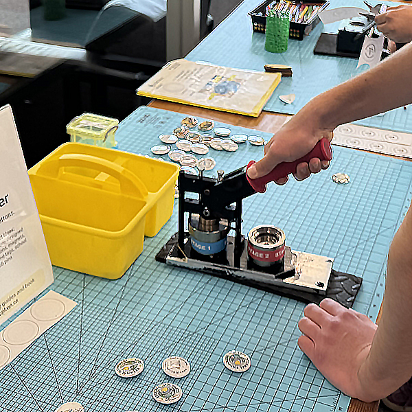 hands of a person using the button maker