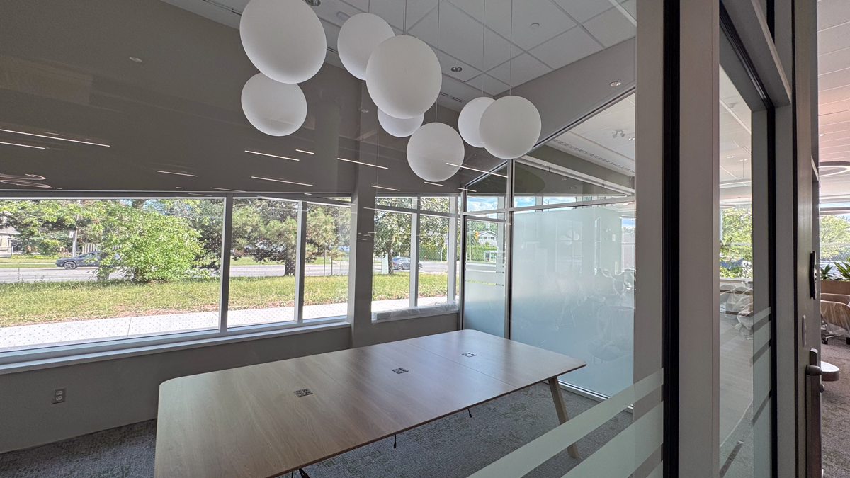 A glass-walled room with a large wood table