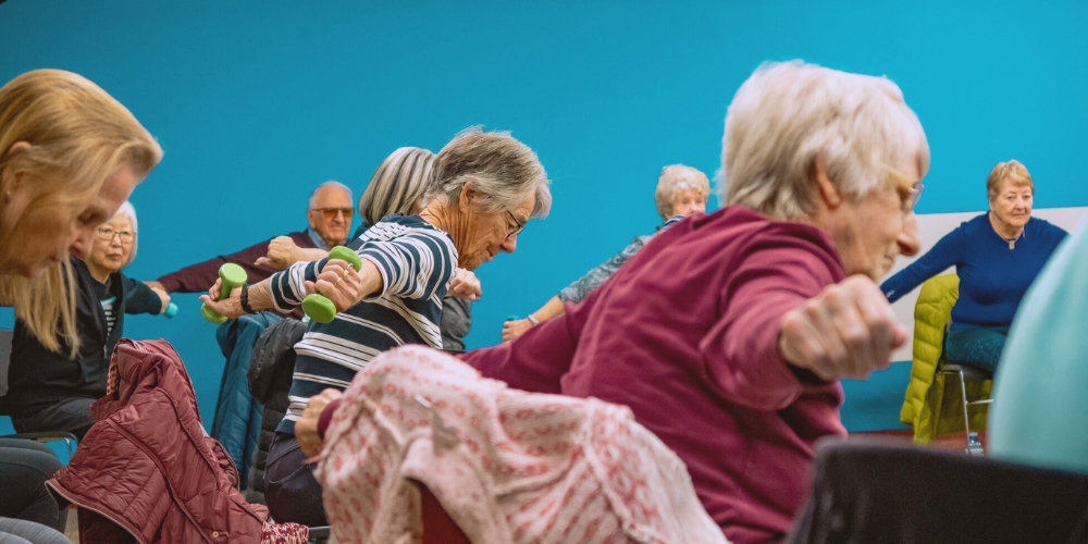 group of older adults exercising in a Sit To Be Fit class