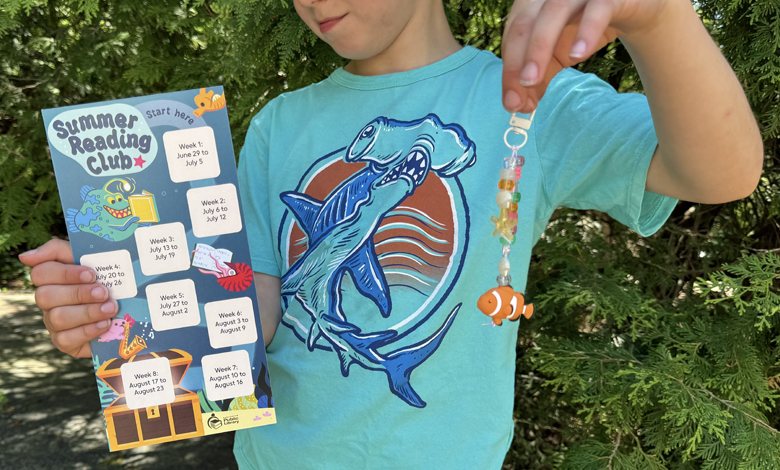 child holding up a tracker and keychain