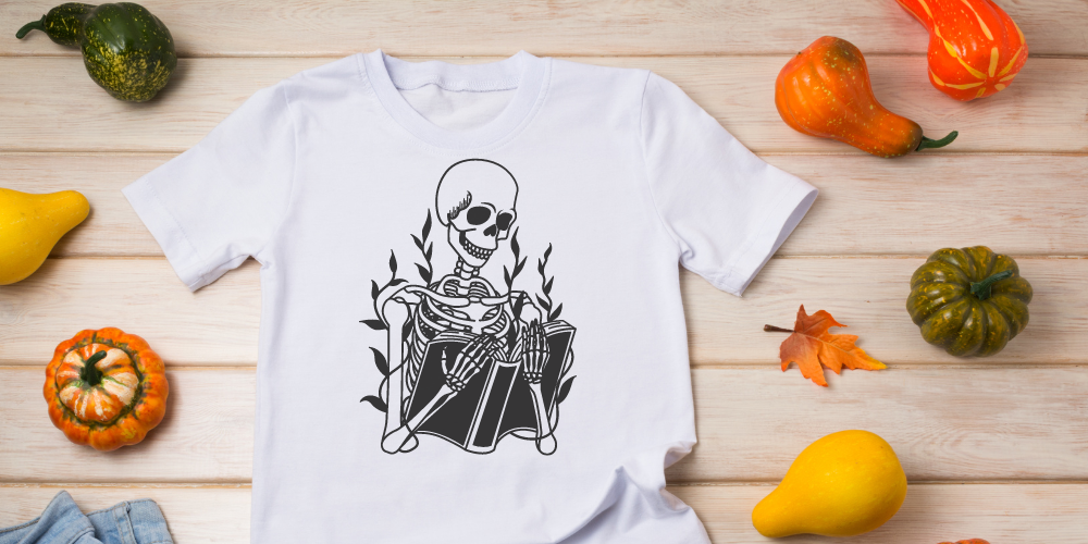 Graphic with a tshirt with a skeleton reading a book against a fall background