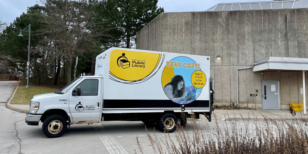 BPL truck with yellow logo and image of woman reading an eBook.
