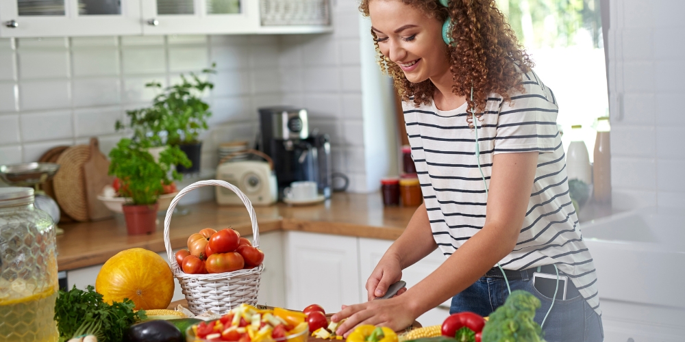 woman cooking in the kitchen with headphone on