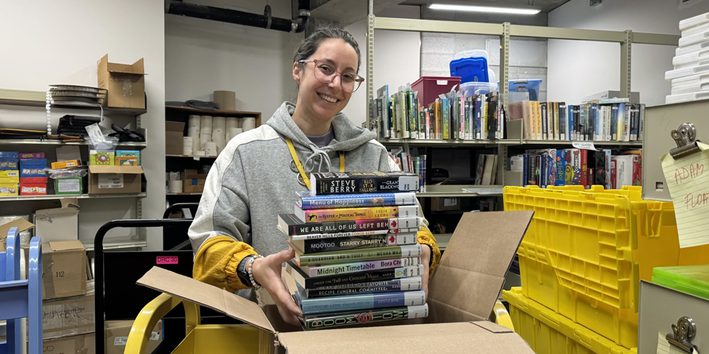 staff removing a stack of 12 books from a box
