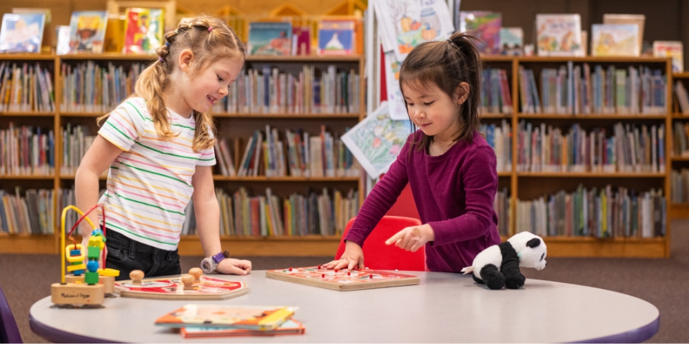 two young children playing with board puzzles
