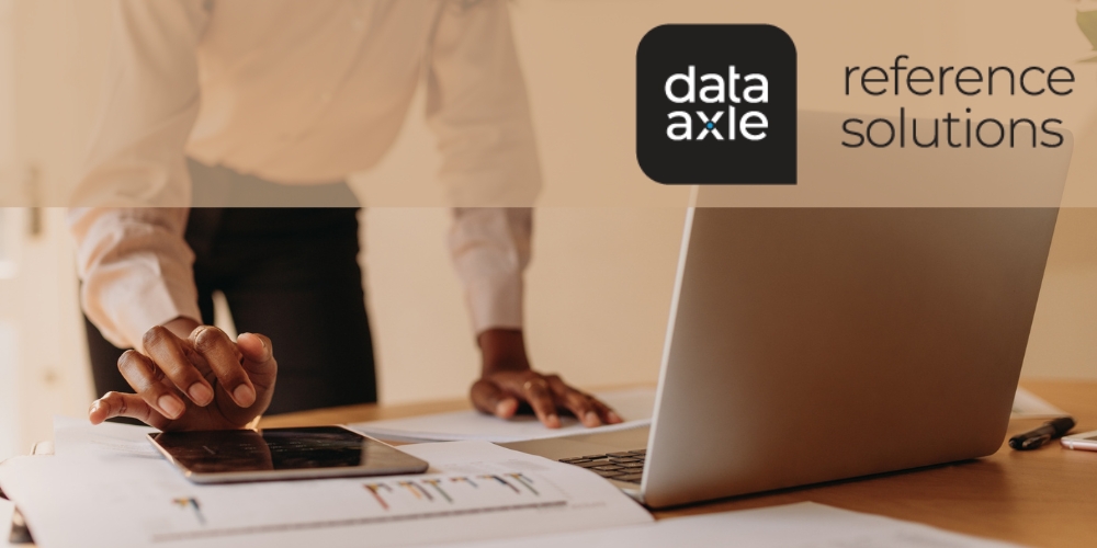 Reference Solutions logo with laptop, papers, and a person standing in the background.