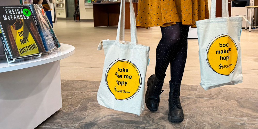 person holding two full library book bags