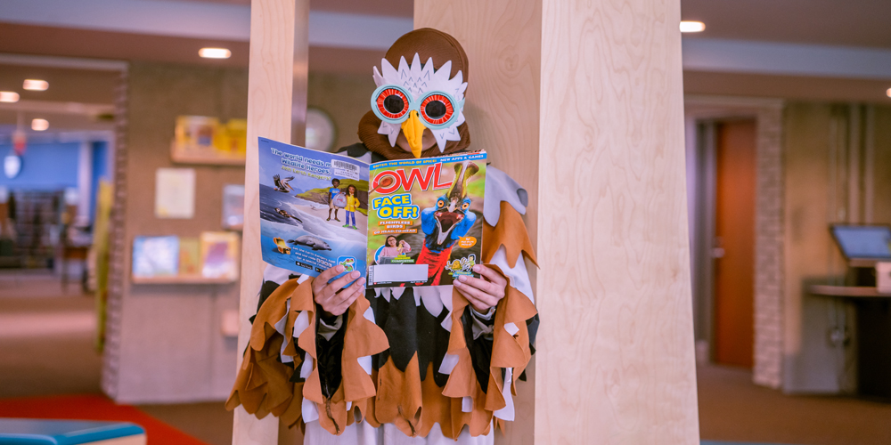 a person in owl costume reading Owl magazine