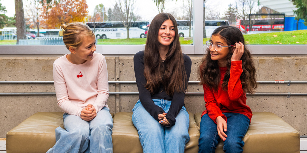 three teens seated on a bench
