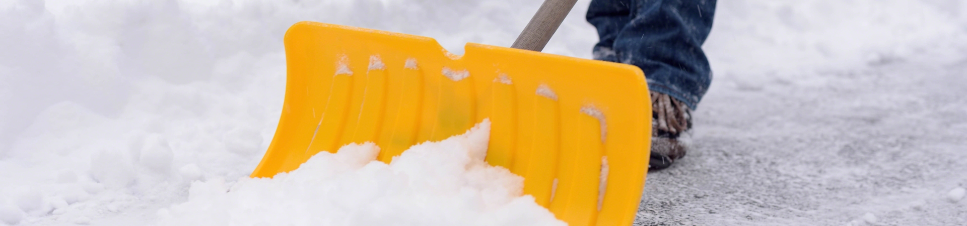 shovelling snow with a yellow shovel